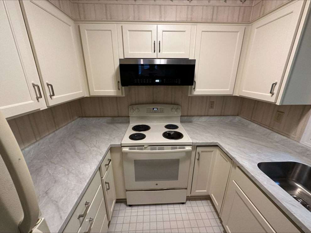 Foto di una piccola cucina parallela classica chiusa con ante in stile shaker, ante bianche e top in laminato