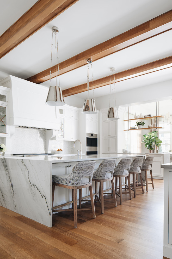 Inspiration for a large transitional light wood floor and brown floor eat-in kitchen remodel in Chicago with an undermount sink, beaded inset cabinets, white cabinets, quartz countertops, stone tile backsplash, paneled appliances, two islands and white countertops