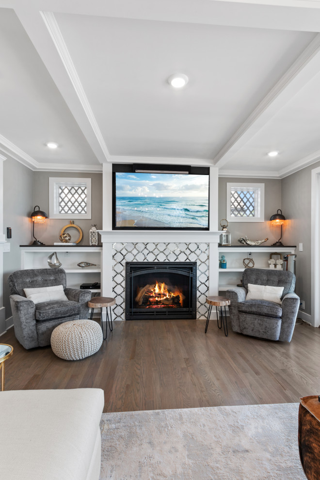 Large contemporary open concept living room in Milwaukee with a home bar, grey walls, light hardwood floors, a standard fireplace, a tile fireplace surround, a wall-mounted tv, beige floor and coffered.