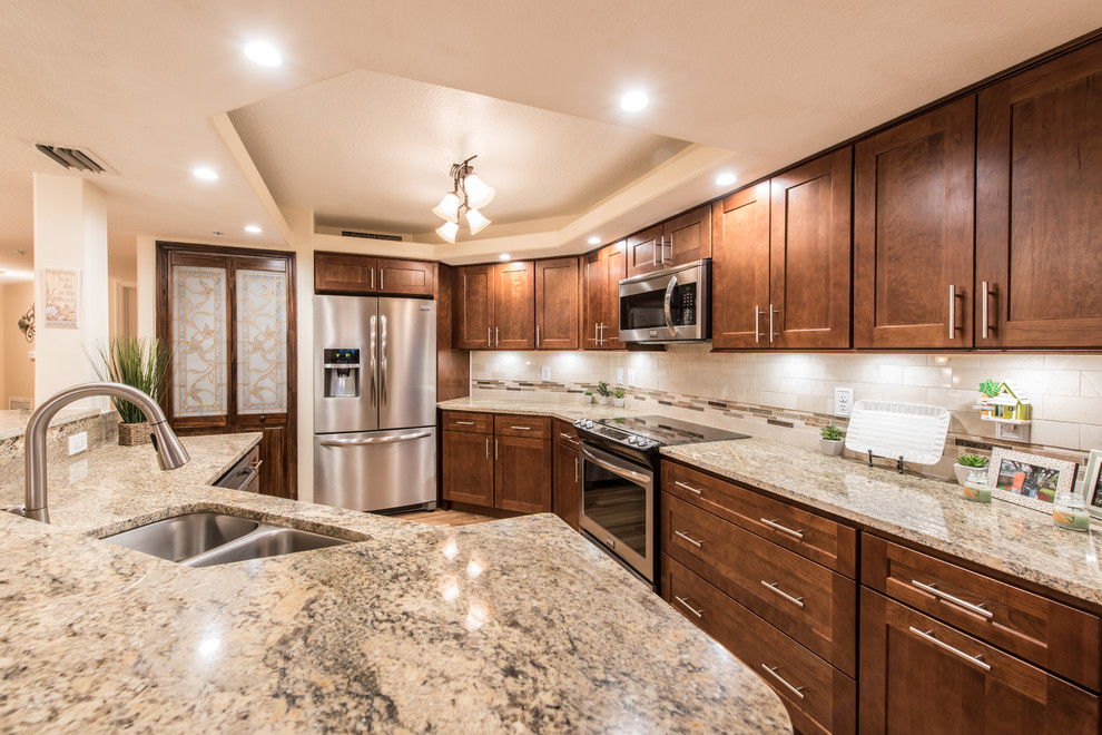 Example of a mid-sized transitional u-shaped porcelain tile eat-in kitchen design with an undermount sink, shaker cabinets, dark wood cabinets, granite countertops, beige backsplash, stone tile backsplash, stainless steel appliances and an island