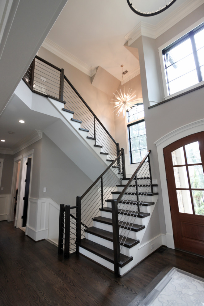 This is an example of a large contemporary wood u-shaped staircase in DC Metro with wood risers and mixed railing.