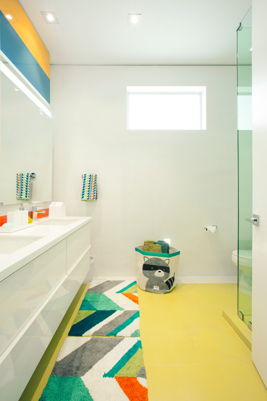 This is an example of a contemporary kids bathroom in Miami with an undermount sink, white cabinets, quartzite benchtops, a corner shower, a one-piece toilet, porcelain tile, white walls and porcelain floors.