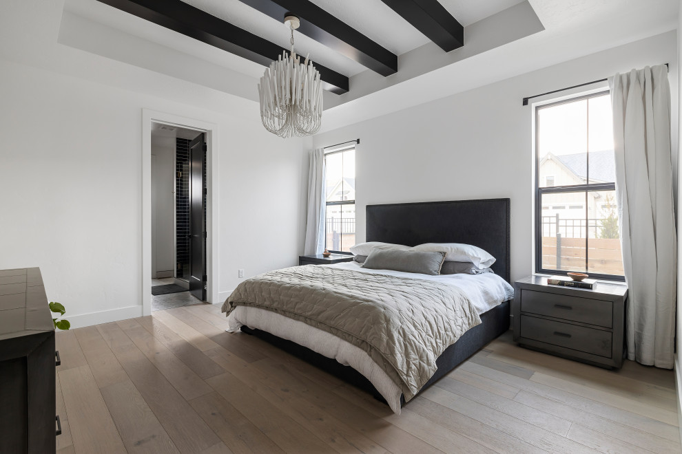 Mittelgroßes Nordisches Hauptschlafzimmer ohne Kamin mit weißer Wandfarbe, hellem Holzboden, beigem Boden und freigelegten Dachbalken in Boise