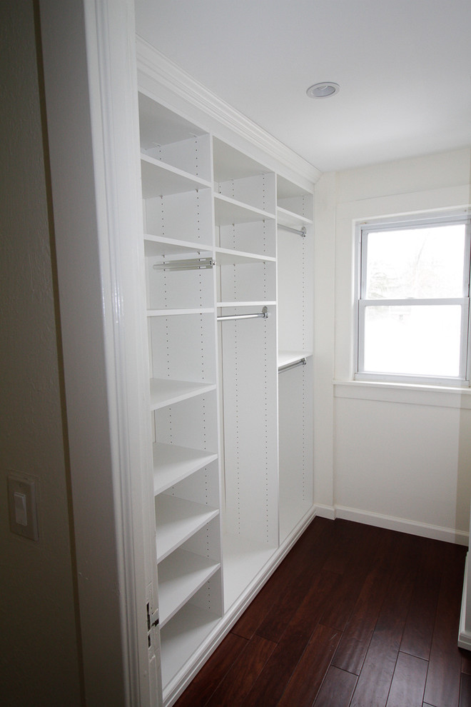 Design ideas for a small traditional women's walk-in wardrobe in New York with open cabinets, white cabinets and dark hardwood floors.