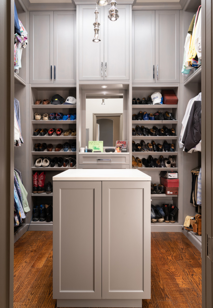 Large transitional men's walk-in wardrobe in Dallas with grey cabinets, medium hardwood floors, brown floor and shaker cabinets.