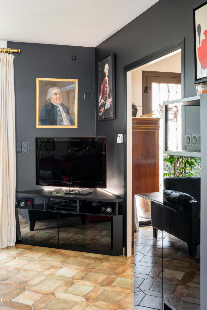 На фото: открытая гостиная комната среднего размера в классическом стиле с с книжными шкафами и полками, черными стенами и телевизором в углу