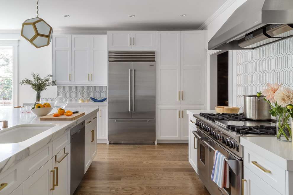 Photo of a large transitional open plan kitchen in San Francisco with a drop-in sink, white cabinets, multi-coloured splashback, glass tile splashback, stainless steel appliances, medium hardwood floors, with island and shaker cabinets.