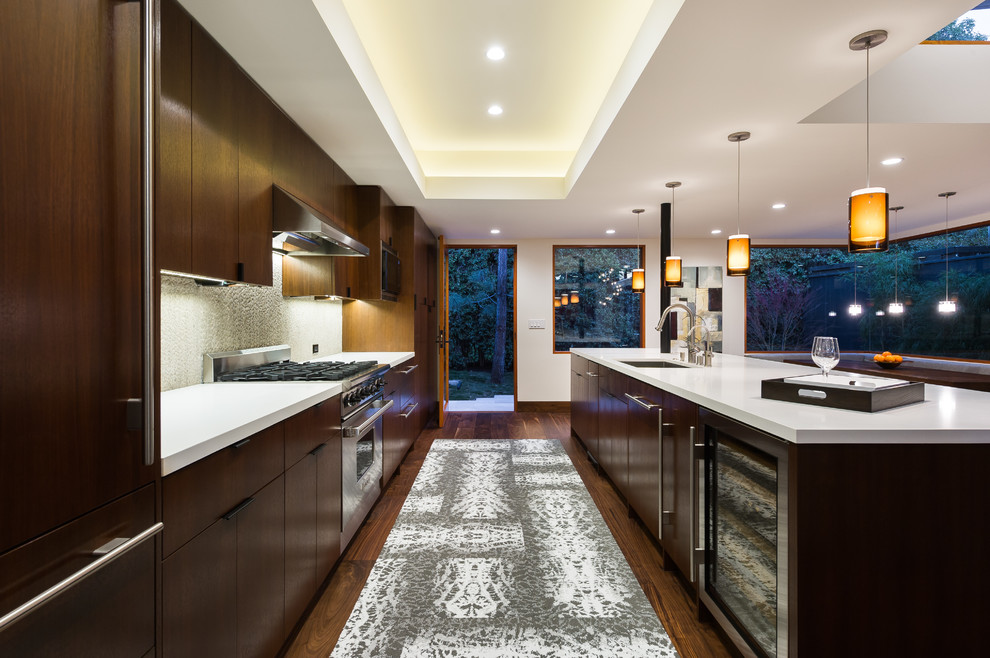 Inspiration for a mid-sized modern single-wall eat-in kitchen in Los Angeles with an undermount sink, flat-panel cabinets, dark wood cabinets, quartzite benchtops, grey splashback, stone slab splashback, panelled appliances, medium hardwood floors, with island and brown floor.