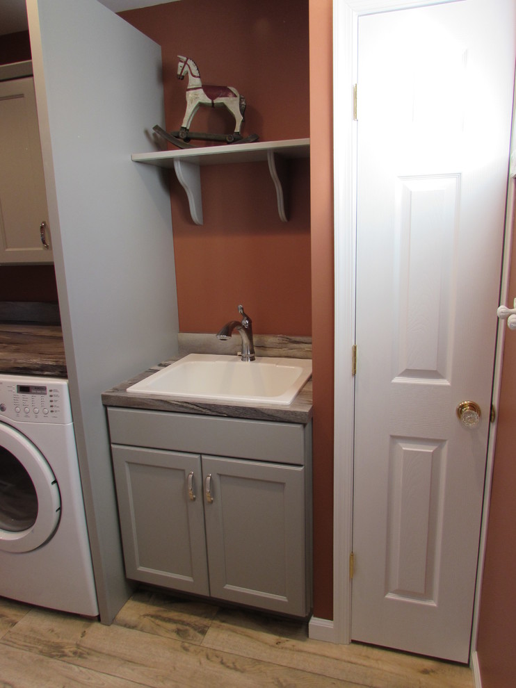 Inspiration for a small transitional single-wall dedicated laundry room remodel with a drop-in sink, recessed-panel cabinets, gray cabinets, laminate countertops and a side-by-side washer/dryer