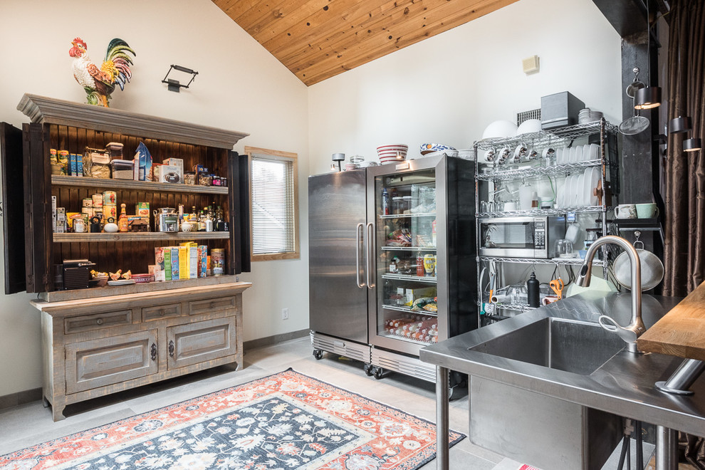 This is an example of a mid-sized industrial u-shaped eat-in kitchen in Kansas City with an integrated sink, open cabinets, stainless steel cabinets, stainless steel benchtops, white splashback, stainless steel appliances, porcelain floors and no island.