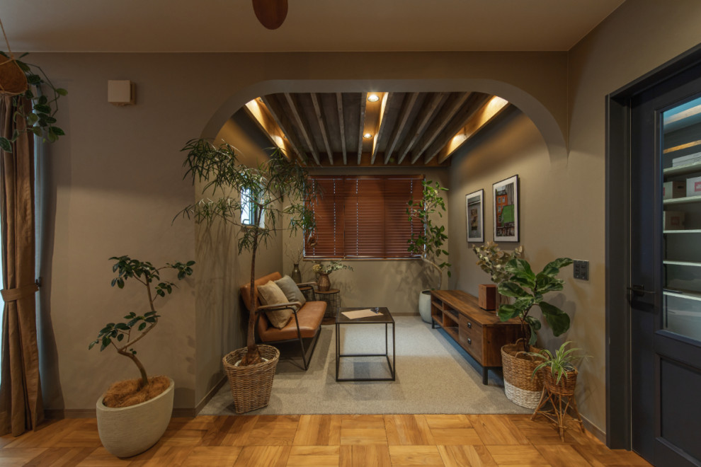 Идея дизайна: маленькая гостиная комната в современном стиле с с книжными шкафами и полками, бежевыми стенами, паркетным полом среднего тона, коричневым полом и обоями на стенах без камина, телевизора для на участке и в саду