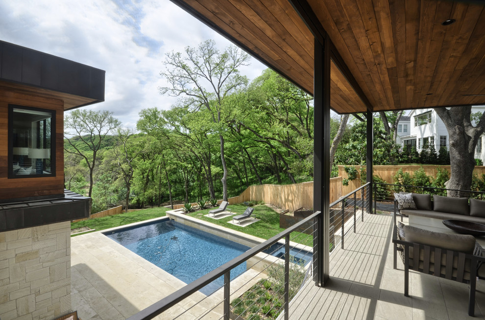 Design ideas for a large contemporary backyard deck in Austin with a roof extension.