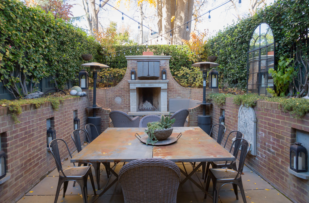 This is an example of a transitional backyard patio in DC Metro with a fire feature, natural stone pavers and no cover.