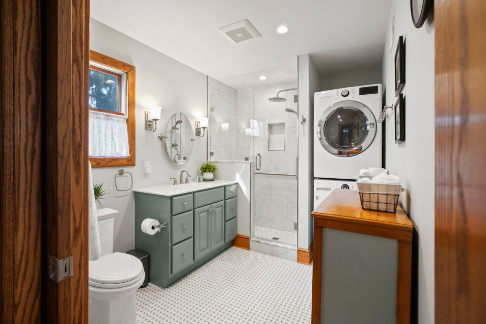 Mid-sized transitional multicolored floor and single-sink bathroom/laundry room photo in New York with gray walls, marble countertops, a hinged shower door and white countertops