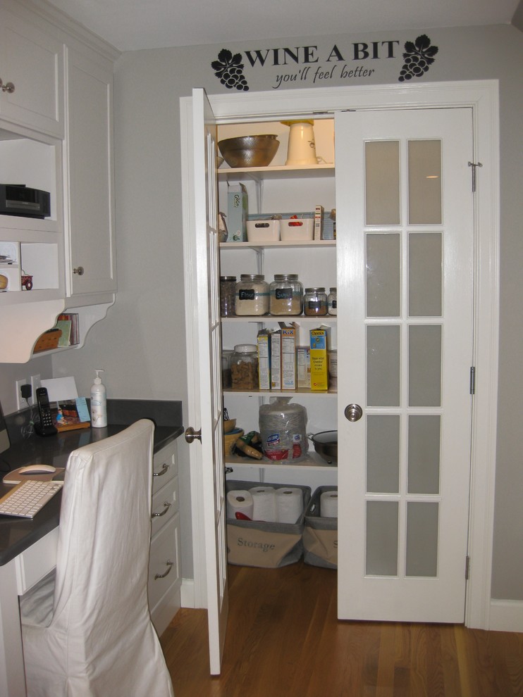 Inspiration for a transitional l-shaped medium tone wood floor eat-in kitchen remodel in Boston with an undermount sink, white cabinets, quartz countertops, stainless steel appliances, an island, shaker cabinets, green backsplash, subway tile backsplash and black countertops