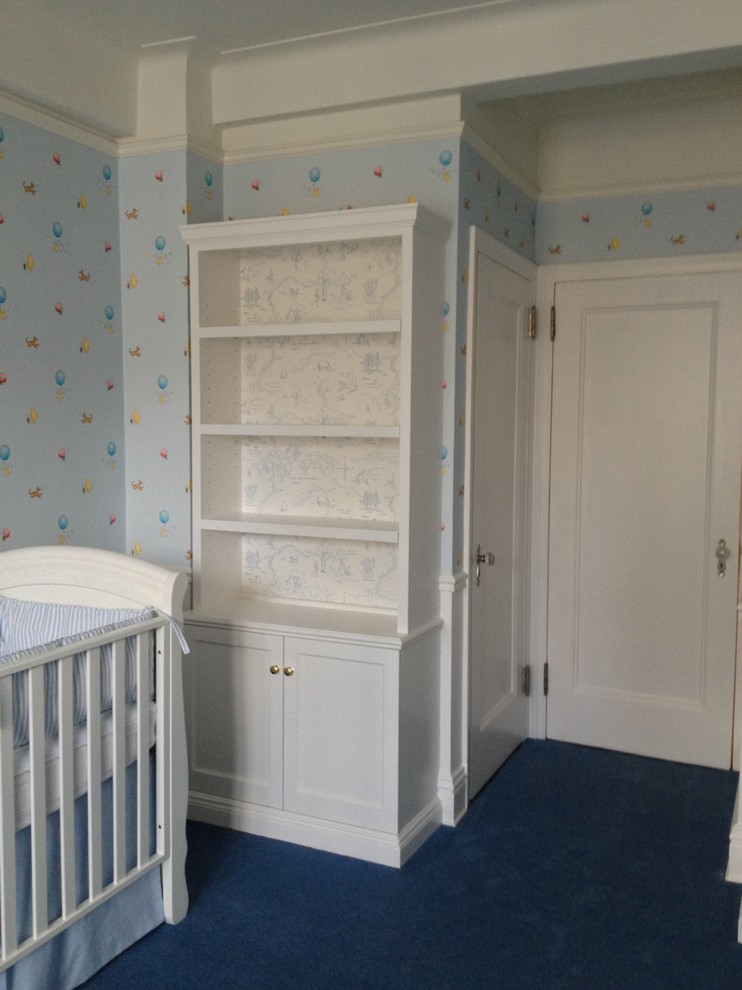 Design ideas for a mid-sized traditional nursery for boys in New York with blue walls and carpet.