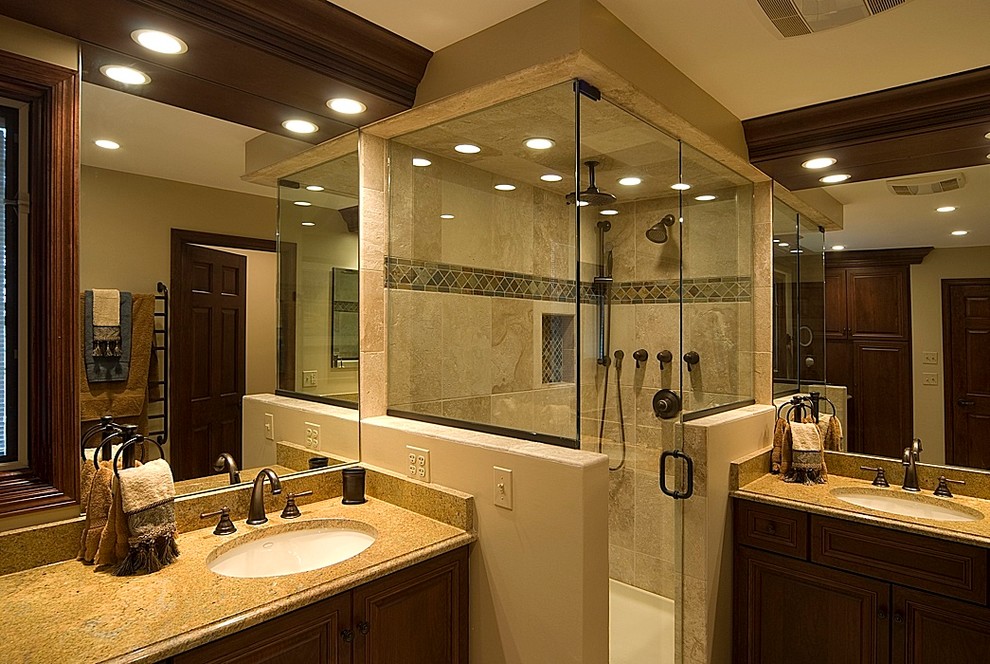 Photo of a mid-sized traditional master bathroom in Houston with raised-panel cabinets, dark wood cabinets, a corner shower, brown tile, ceramic tile, an undermount sink, granite benchtops, a hinged shower door and brown walls.