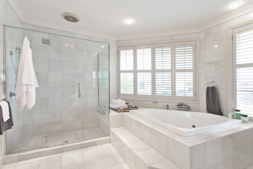 This is an example of a large traditional master bathroom in New York with a hot tub, a double shower, a two-piece toilet, white tile, porcelain tile, white walls, porcelain floors, a vessel sink, white floor and a hinged shower door.