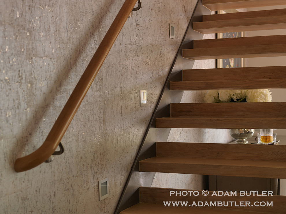 This is an example of a mid-sized contemporary wood straight staircase in London with open risers.