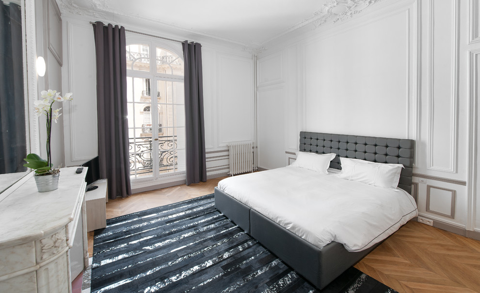 Design ideas for a large contemporary master bedroom in Paris with white walls and medium hardwood floors.