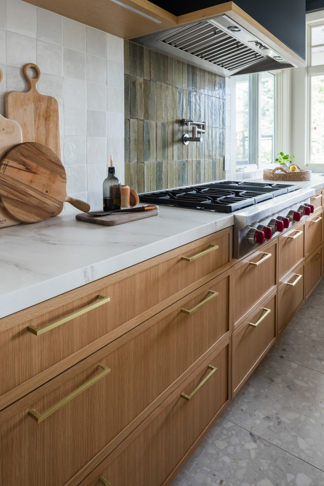 Large eclectic l-shaped kitchen/diner in Vancouver with a submerged sink, shaker cabinets, light wood cabinets, marble worktops, green splashback, porcelain splashback, stainless steel appliances, an island, white worktops, porcelain flooring and grey floors.