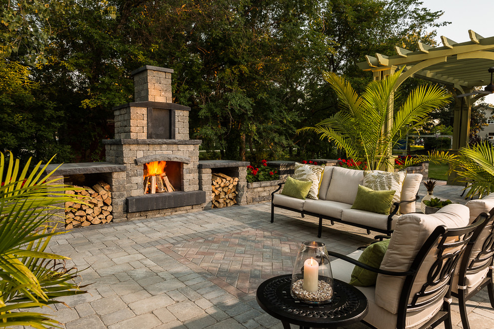 Inspiration for a large tropical backyard patio in Other with no cover, brick pavers and with fireplace.