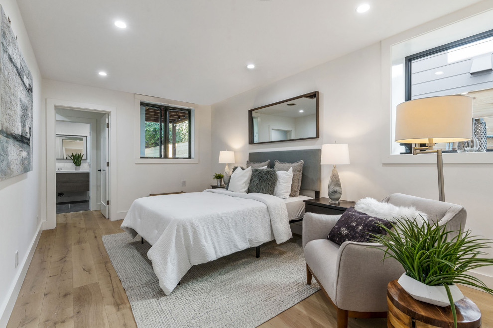 Design ideas for a mid-sized contemporary guest bedroom in San Francisco with white walls, light hardwood floors and beige floor.