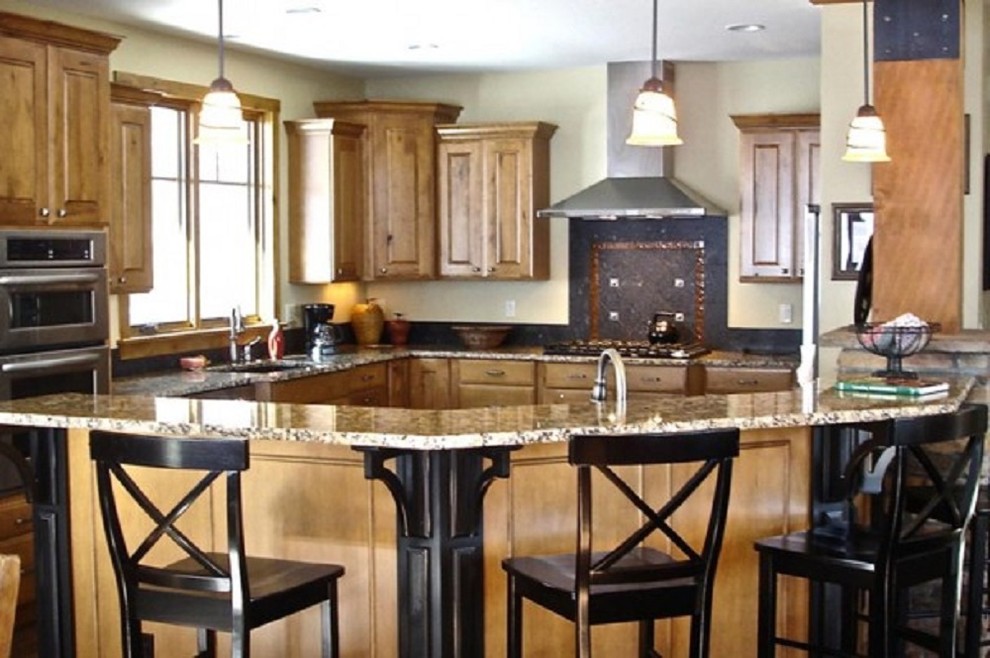 Mid-sized mountain style l-shaped medium tone wood floor open concept kitchen photo in Denver with a double-bowl sink, raised-panel cabinets, medium tone wood cabinets, granite countertops, black backsplash, porcelain backsplash, stainless steel appliances and an island