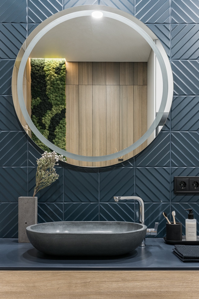 Inspiration for a mid-sized contemporary bathroom in Yekaterinburg with flat-panel cabinets, medium wood cabinets, blue tile, ceramic tile, blue walls, a vessel sink, solid surface benchtops, blue benchtops, a floating vanity and a single vanity.