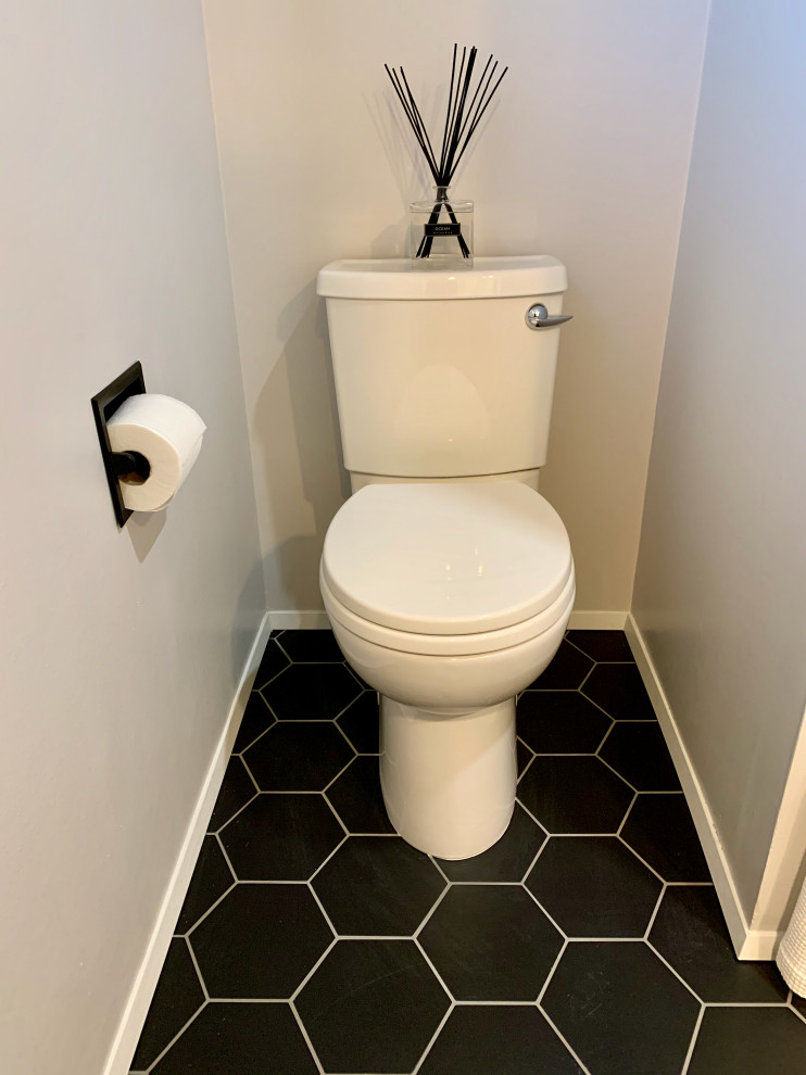 Powder room - mid-sized 1950s white tile and subway tile porcelain tile and black floor powder room idea in Seattle with a two-piece toilet, gray walls, flat-panel cabinets, medium tone wood cabinets, quartz countertops and white countertops