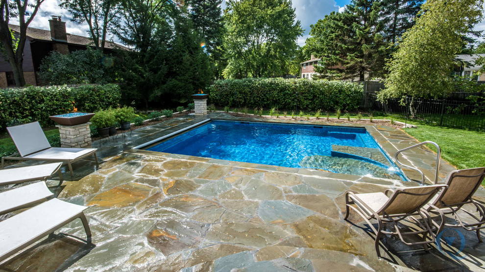 Inspiration for a mid-sized rustic backyard stone and rectangular lap pool fountain remodel in Chicago