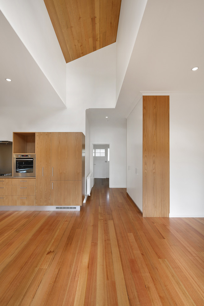 Photo of a large contemporary open concept living room in Melbourne with white walls and light hardwood floors.