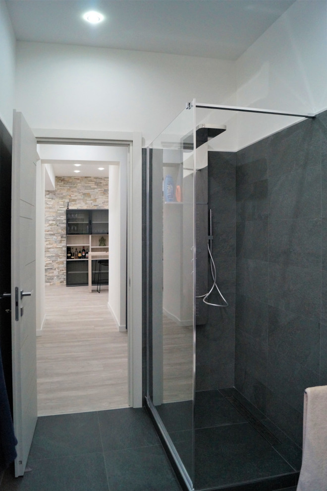 Mid-sized modern 3/4 bathroom in Other with flat-panel cabinets, red cabinets, a corner shower, a wall-mount toilet, gray tile, porcelain tile, grey walls, laminate floors, a vessel sink, grey floor, an open shower, red benchtops, a single vanity and a floating vanity.