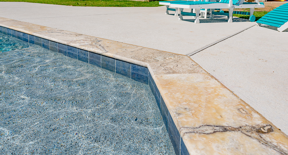 Large traditional backyard custom-shaped natural pool in Other with a hot tub and concrete slab.