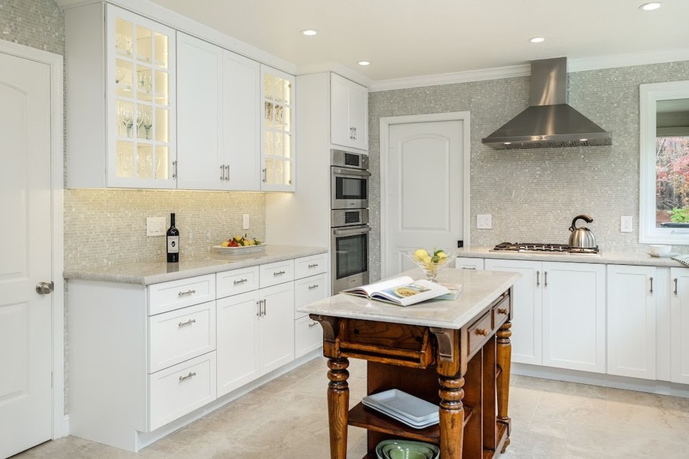 Eat-in kitchen - large transitional u-shaped limestone floor eat-in kitchen idea with an undermount sink, shaker cabinets, white cabinets, marble countertops, metallic backsplash, mosaic tile backsplash, stainless steel appliances and an island