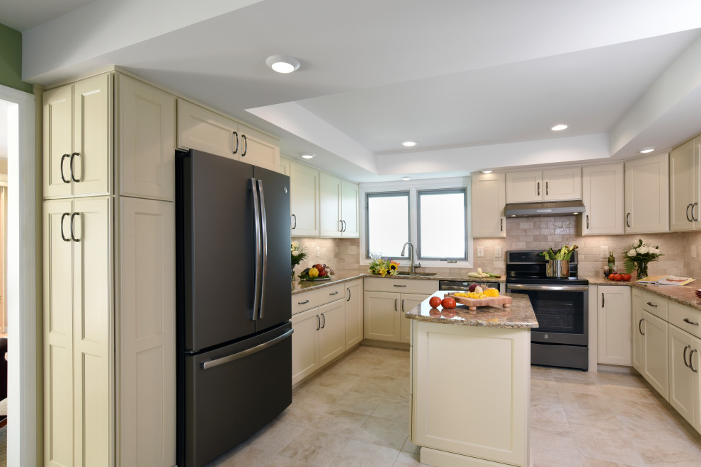 Example of a mid-sized transitional u-shaped porcelain tile, beige floor and tray ceiling enclosed kitchen design with an undermount sink, flat-panel cabinets, beige cabinets, quartz countertops, beige backsplash, travertine backsplash, black appliances, an island and beige countertops