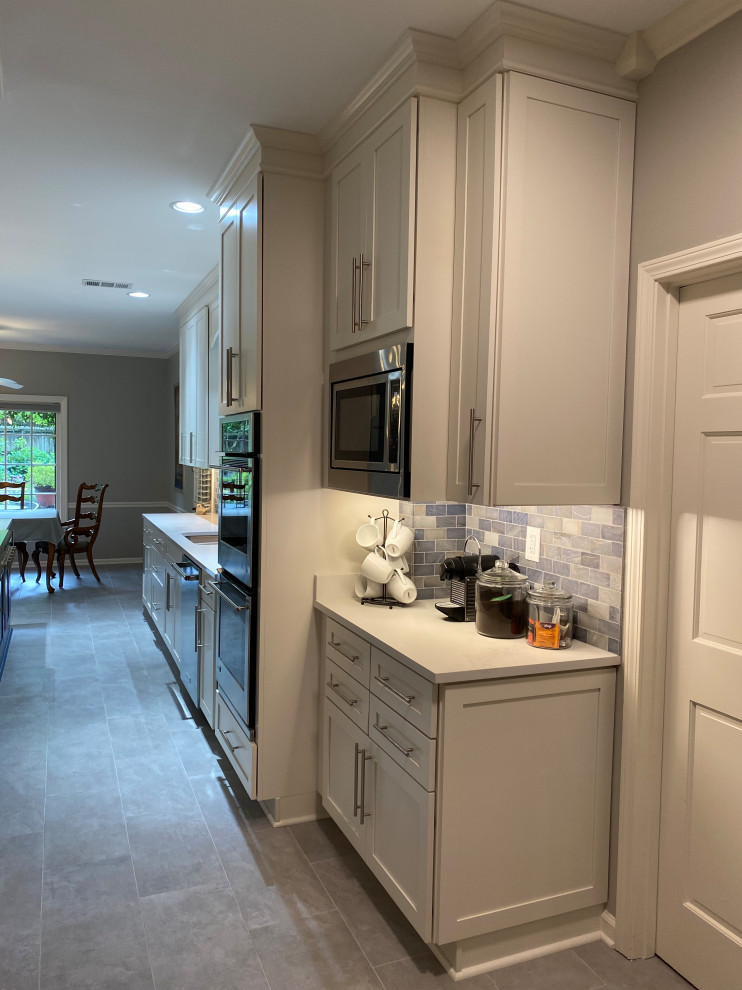 Inspiration for a large traditional galley kitchen in Other with an undermount sink, shaker cabinets, white cabinets, quartz benchtops, blue splashback, stone tile splashback, stainless steel appliances, porcelain floors, with island, grey floor and white benchtop.
