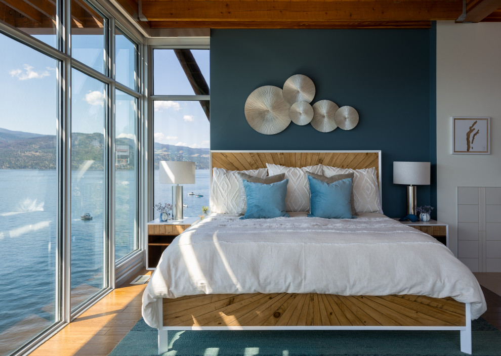 Inspiration pour une chambre marine avec un mur bleu, un sol en bois brun, un sol marron et poutres apparentes.