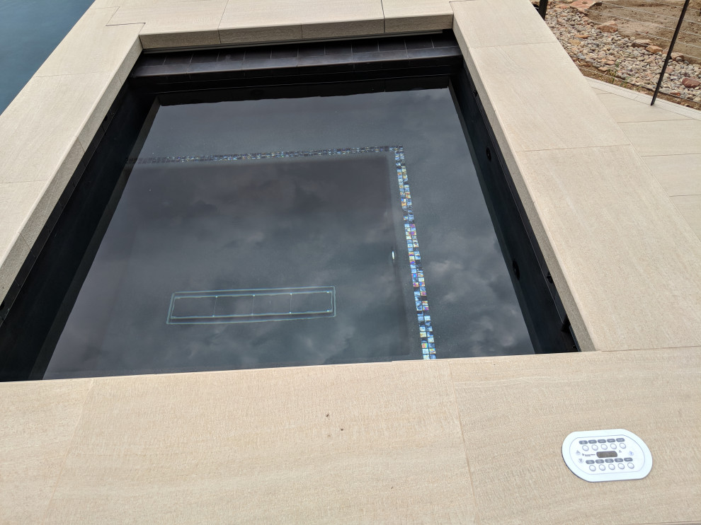 Mid-sized backyard rectangular infinity hot tub photo in Denver