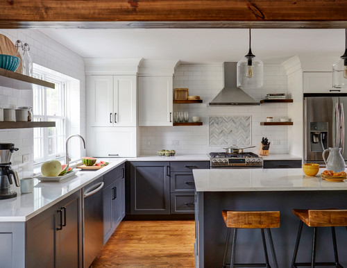 Two-tone kitchen cabinets in Canada: white upper cabinets with charcoal grey base cabinets, quartz countertops, subway tile backsplash, stainless hood, and floating wood shelves