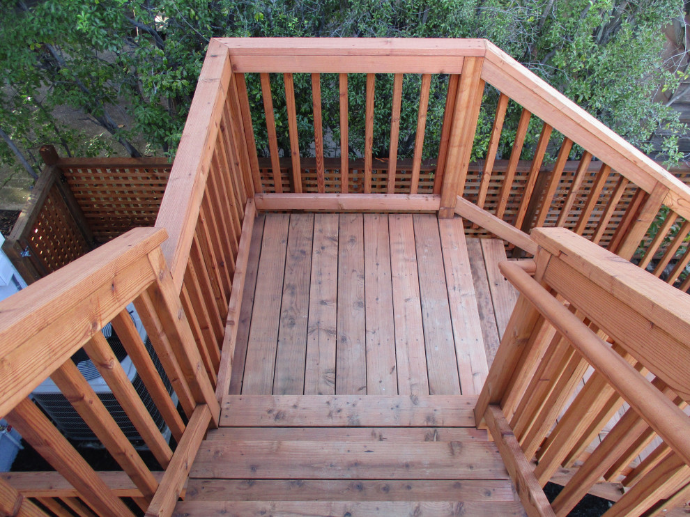 Ejemplo de escalera en L de estilo americano de tamaño medio con escalones de madera, contrahuellas de madera, barandilla de madera y ladrillo