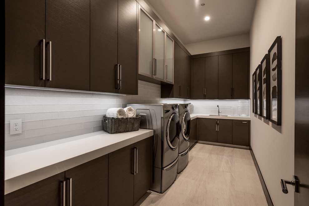 Photo of a mid-sized contemporary l-shaped dedicated laundry room in Las Vegas with an undermount sink, flat-panel cabinets, brown cabinets, quartz benchtops, white walls, porcelain floors, a side-by-side washer and dryer, beige floor and white benchtop.