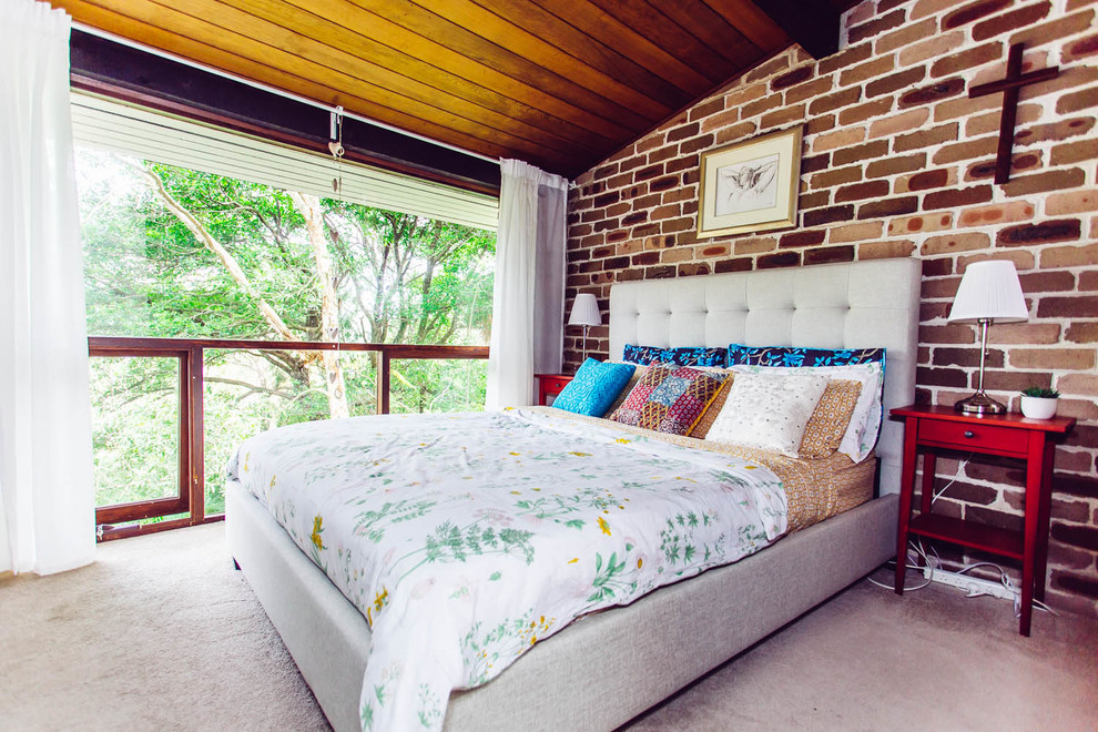 This is an example of a small tropical master bedroom in Sydney with brown walls, carpet and no fireplace.