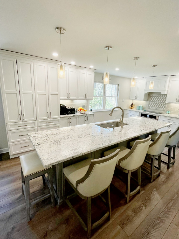 Inspiration for a mid-sized transitional kitchen remodel with an undermount sink, recessed-panel cabinets, white cabinets, granite countertops, gray backsplash, stainless steel appliances and white countertops