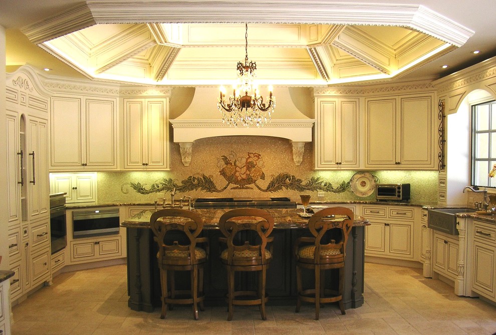This is an example of a large traditional u-shaped open plan kitchen in San Diego with marble benchtops, a farmhouse sink, beaded inset cabinets, beige cabinets, beige splashback, mosaic tile splashback, stainless steel appliances, ceramic floors, with island and beige floor.