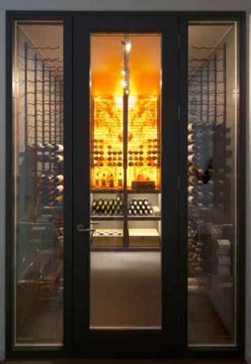 Photo of a large contemporary wine cellar in London with concrete floors, storage racks and beige floor.