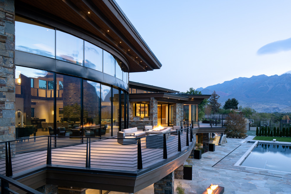 Photo of a large world-inspired back first floor metal railing terrace in Salt Lake City with a fire feature and a roof extension.