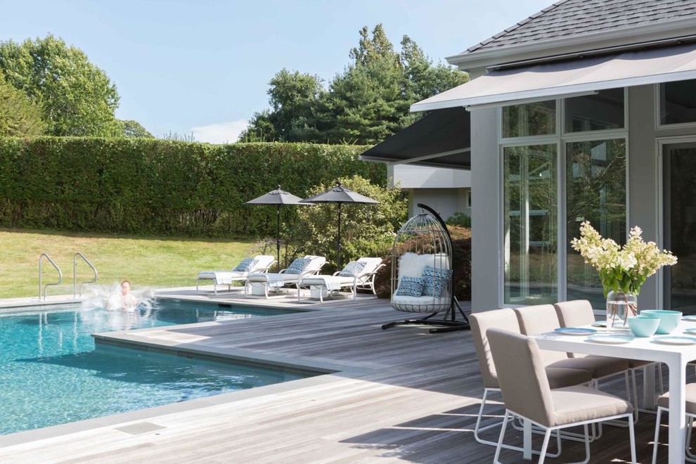 Inspiration for a large beach style backyard rectangular lap pool in New York with decking.