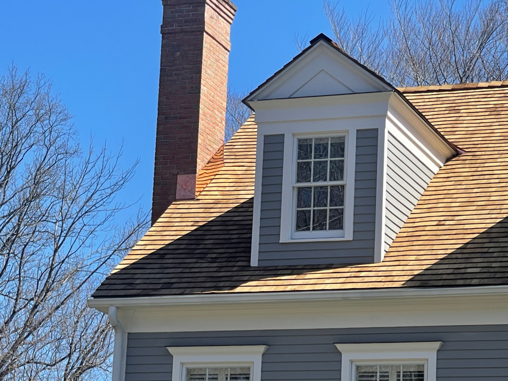 Réalisation d'une très grande façade de maison grise tradition en bois et bardage à clin à deux étages et plus avec un toit à deux pans, un toit en shingle et un toit rouge.