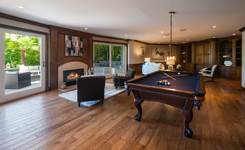 Photo of a large traditional walk-out basement in Sacramento with beige walls, dark hardwood floors, a standard fireplace, a stone fireplace surround and brown floor.